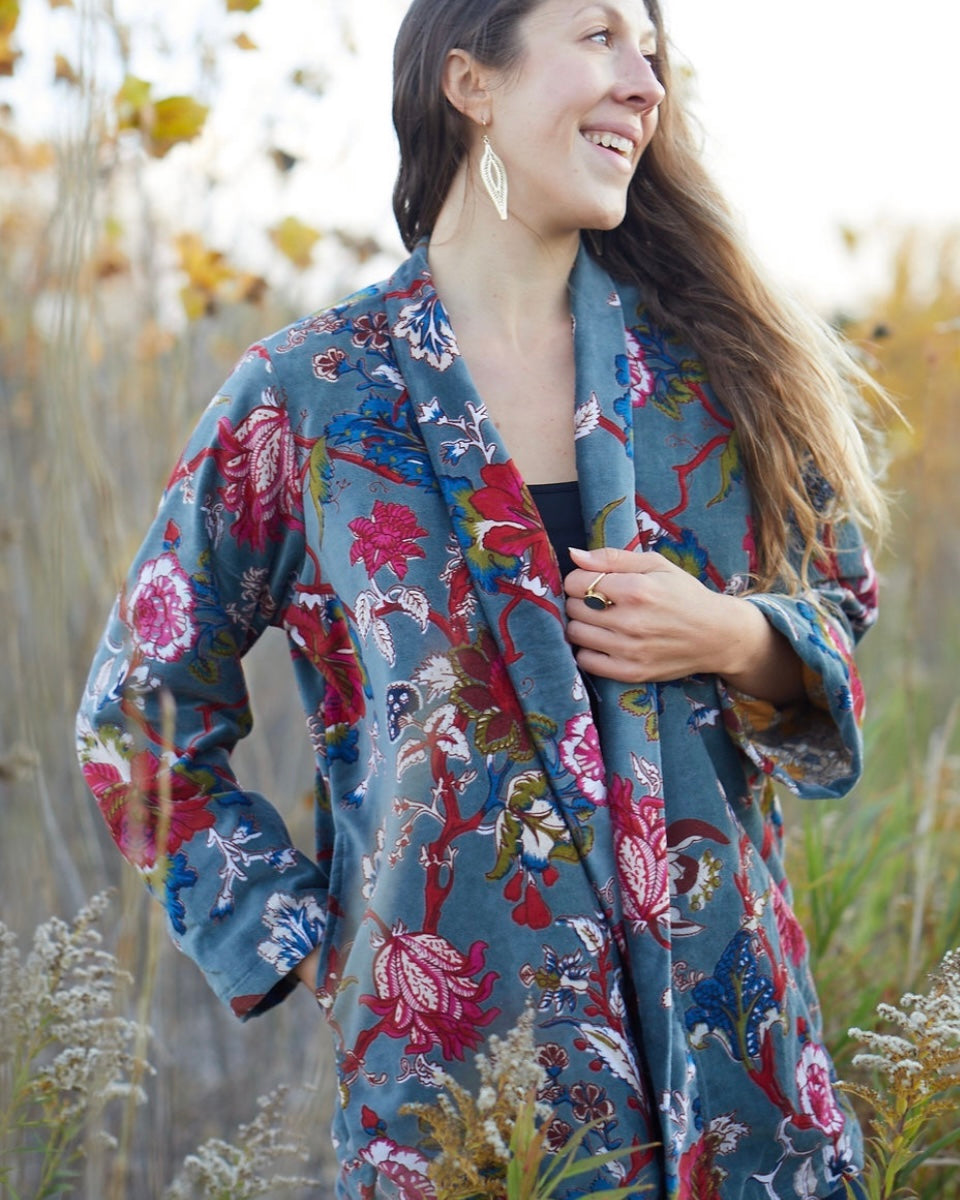 Woman wearing a floral coat standing in a natural setting