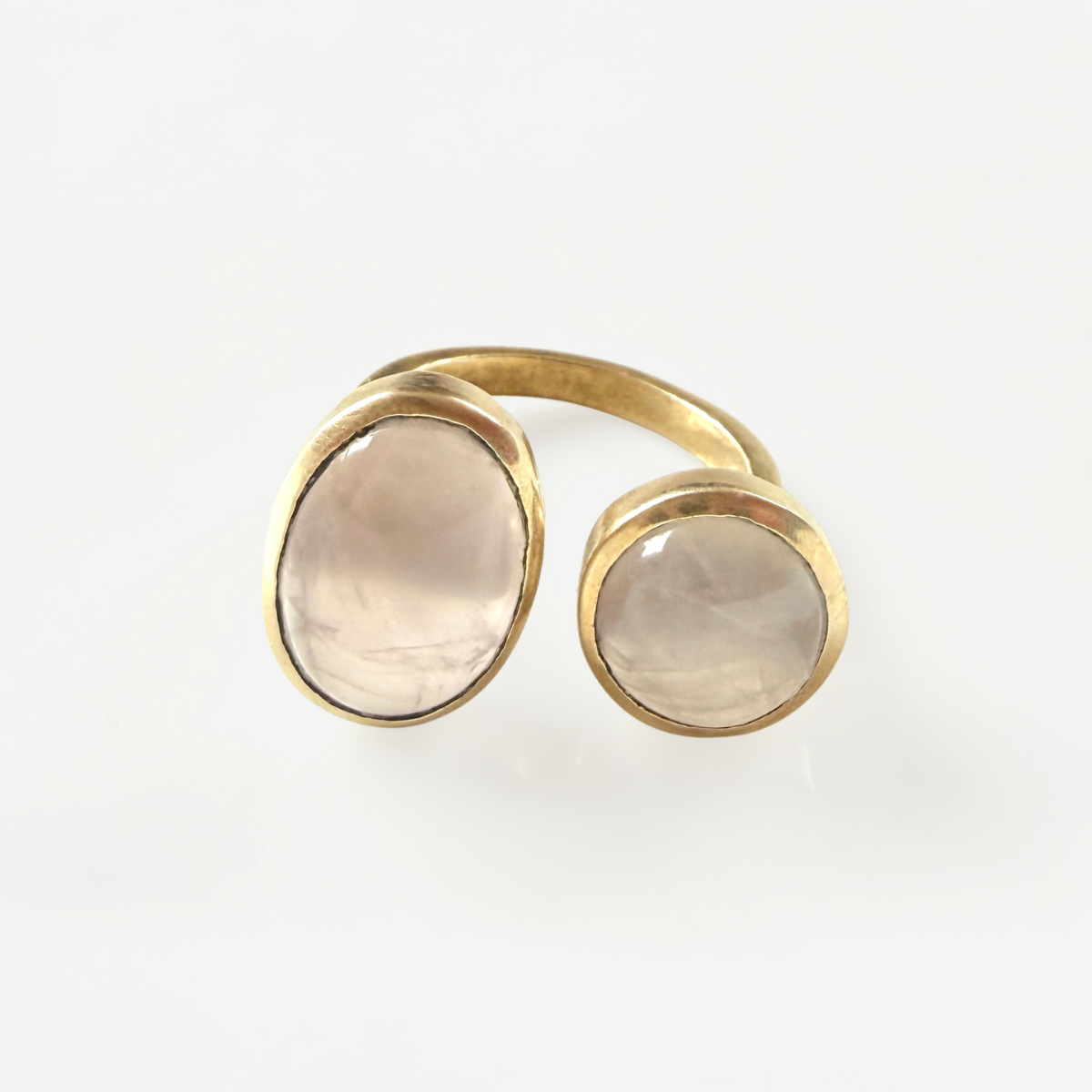 Gold ring with two round stone elements on a white background