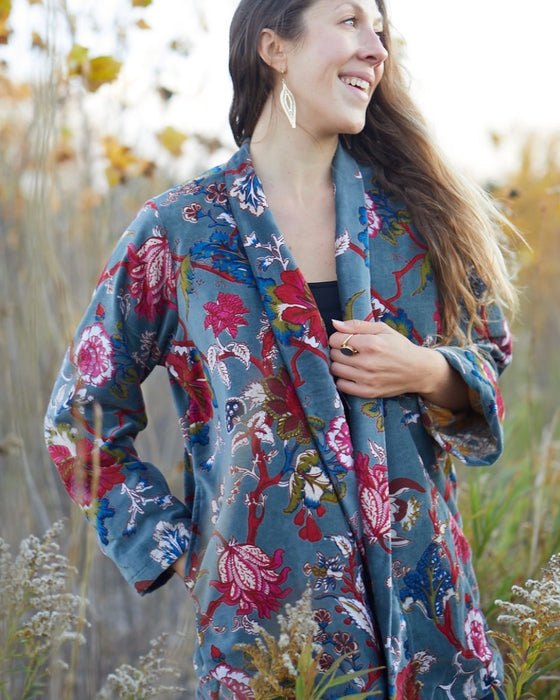 Woman wearing a floral coat standing in a natural setting