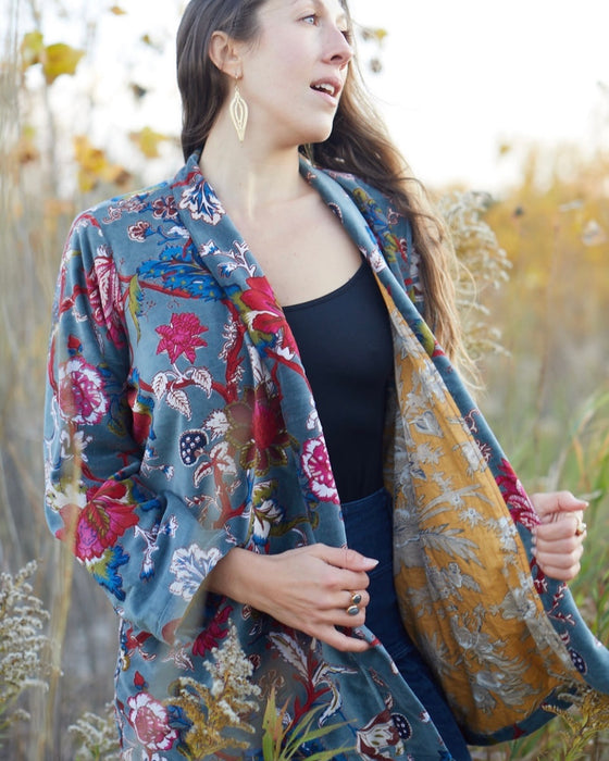 Woman wearing a colorful floral kimono in a natural setting