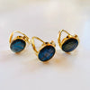 Gold-rimmed blue Labradorite gemstone rings on a white background