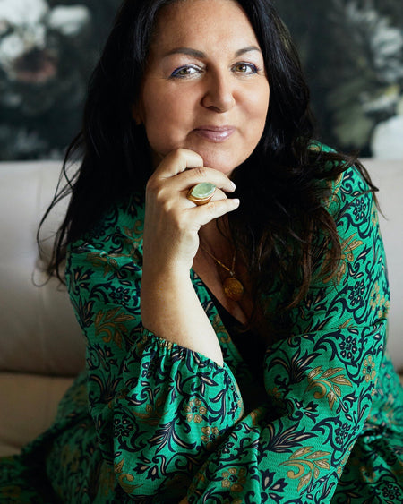 Woman wearing a green patterned dress with a blurred background